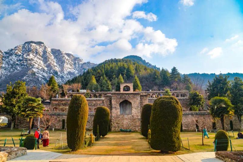 Nishat Bagh Srinagar nearby sights: terraced stone garden with cypress trees and snow-capped mountains