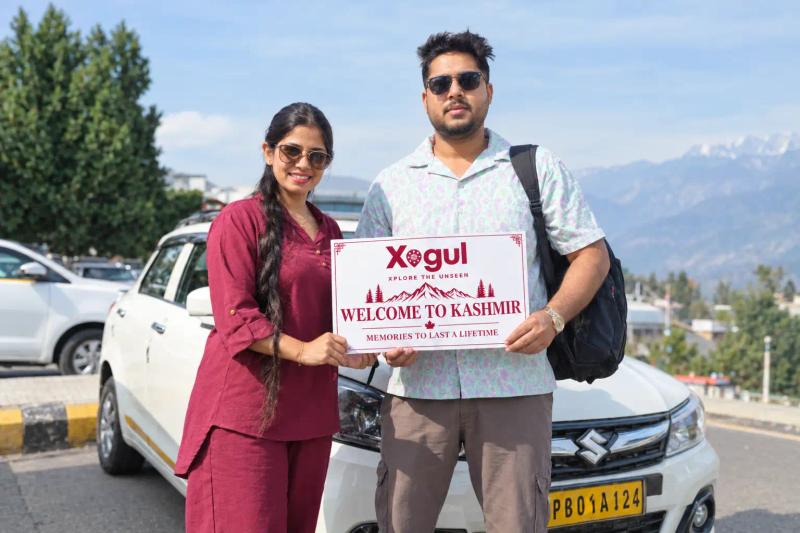 Kashmir tour package price per person: couple with Xogul welcome sign beside a private cab