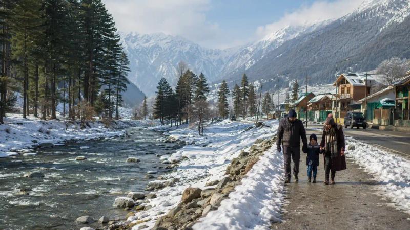Kashmir in December with a family walking beside the snow-covered Lidder River in Pahalgam
