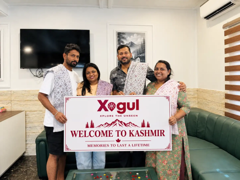 Kashmir tour package price per person: Xogul group travellers with Welcome to Kashmir sign