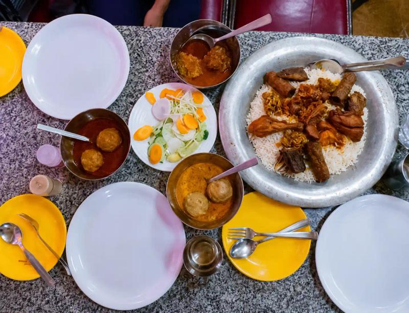 Traditional Kashmiri Wazwan served on a copper trami with authentic meat dishes shared during a traditional Kashmiri feast.