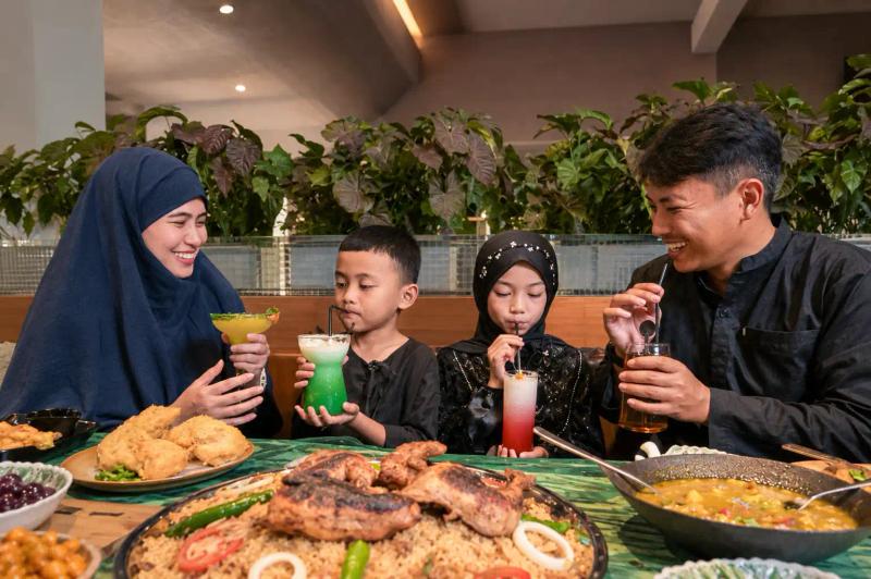 Family sharing a meal with drinks, planning food needs with a Kashmir travel agency for family trips