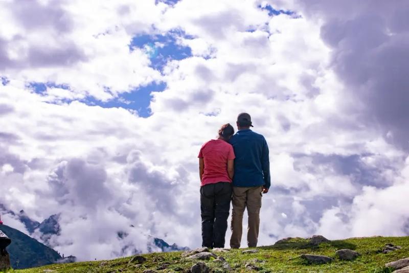 Couple looking at cloudy Kashmir mountains, a trip planned by Kashmir tour operators for family trips