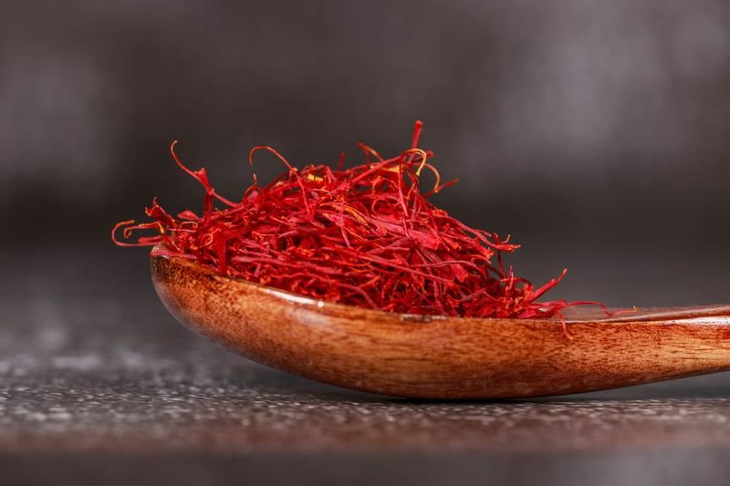 What to Buy in Kashmir – authentic Kashmiri saffron strands displayed on a wooden spoon