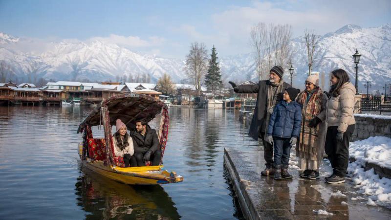 Kashmir in December for couples and families enjoying a Shikara ride beside snowy Dal Lak