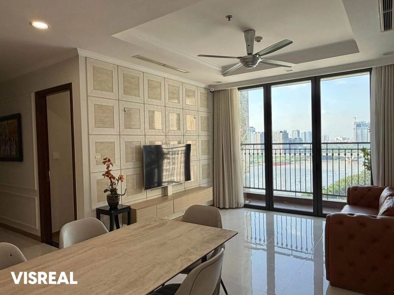Living room and dining area, with a balcony overlooking the river, in this Central 1 apartment