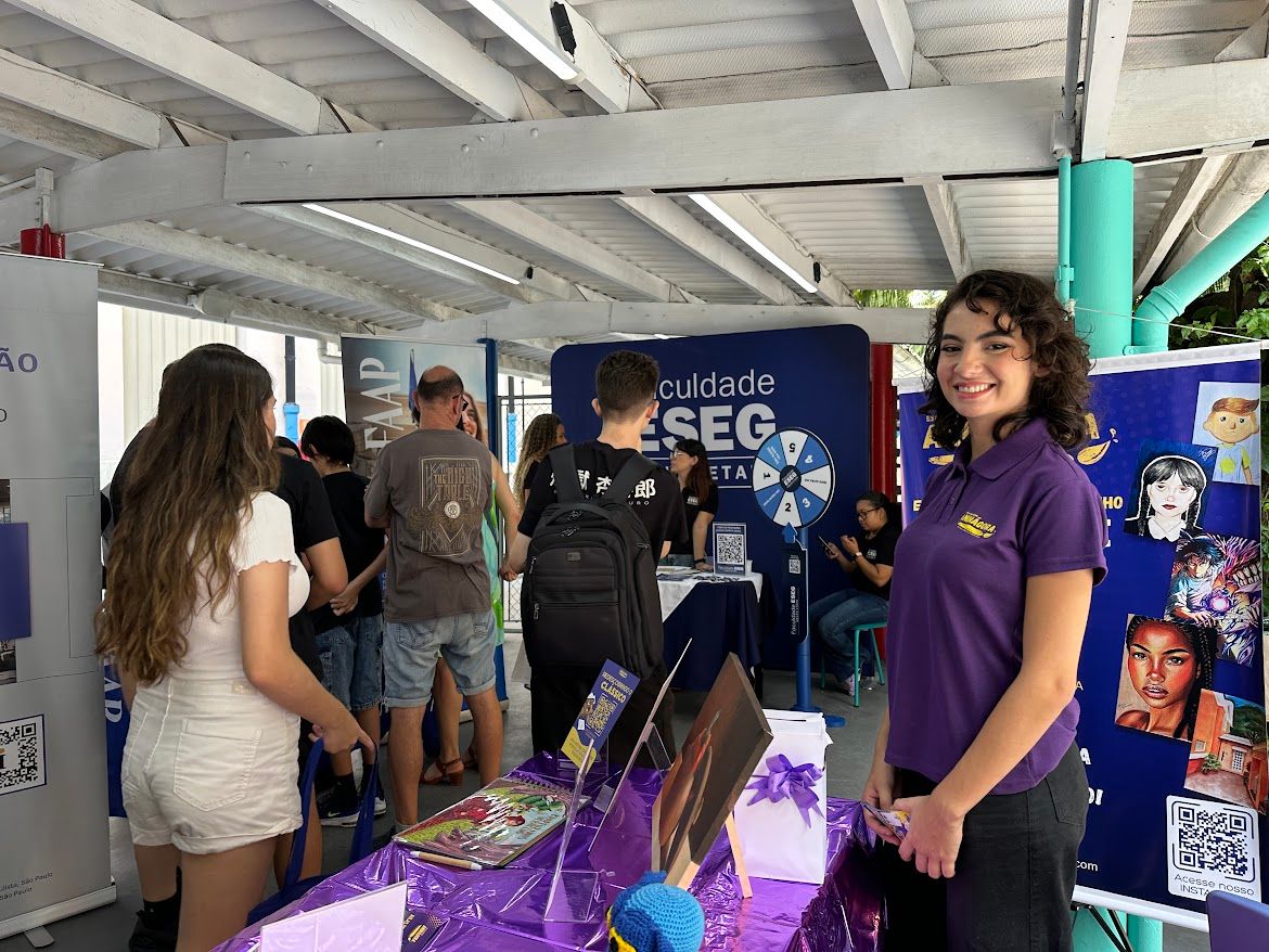 Representante recebe visitantes em um estande universitário durante o Carreiras em Foco 2026