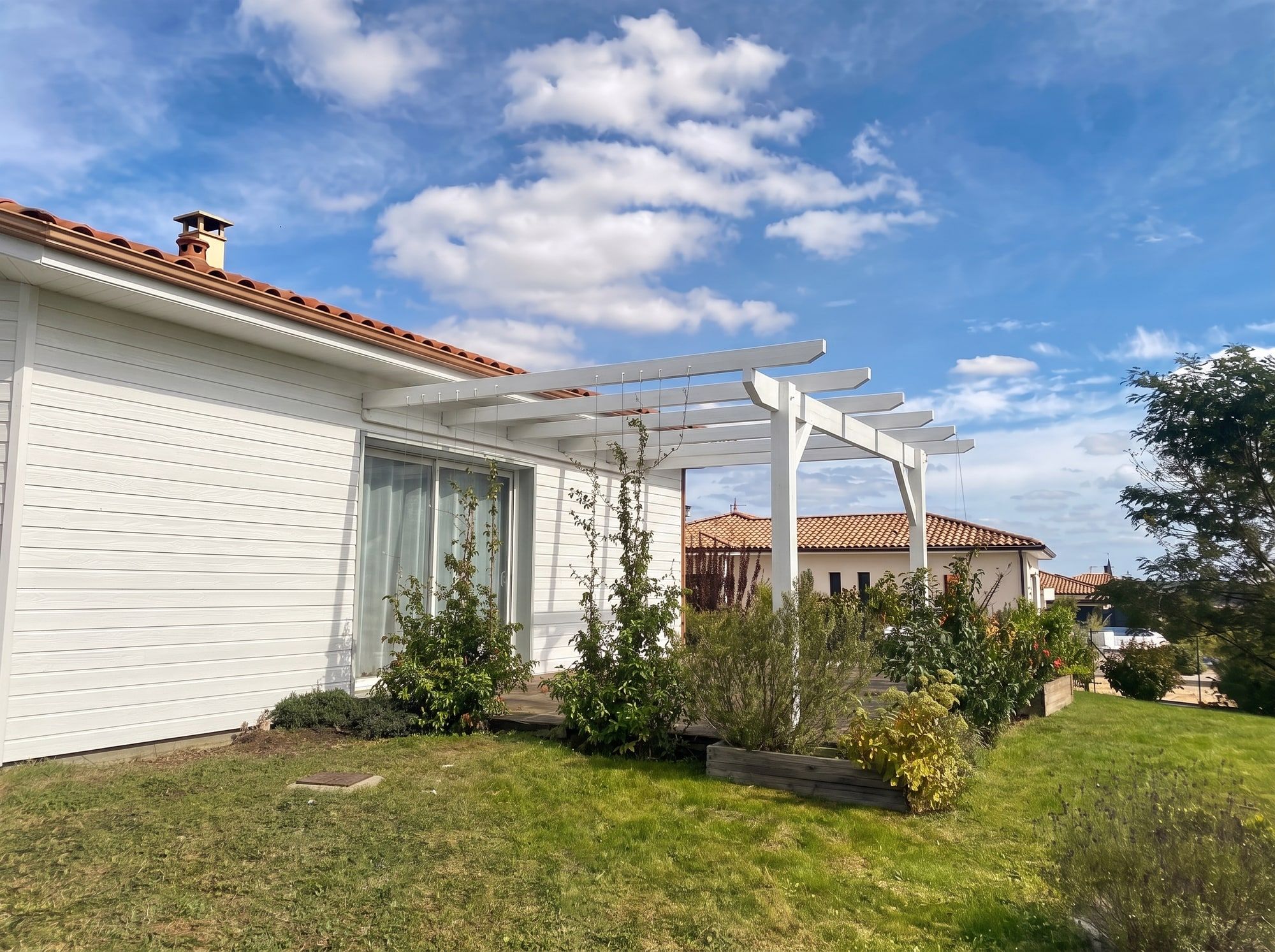Façade et pergola repeintes en blanc cassé après rénovation du bardage bois, Castelnau-sur-Gupie près de Marmande (47)