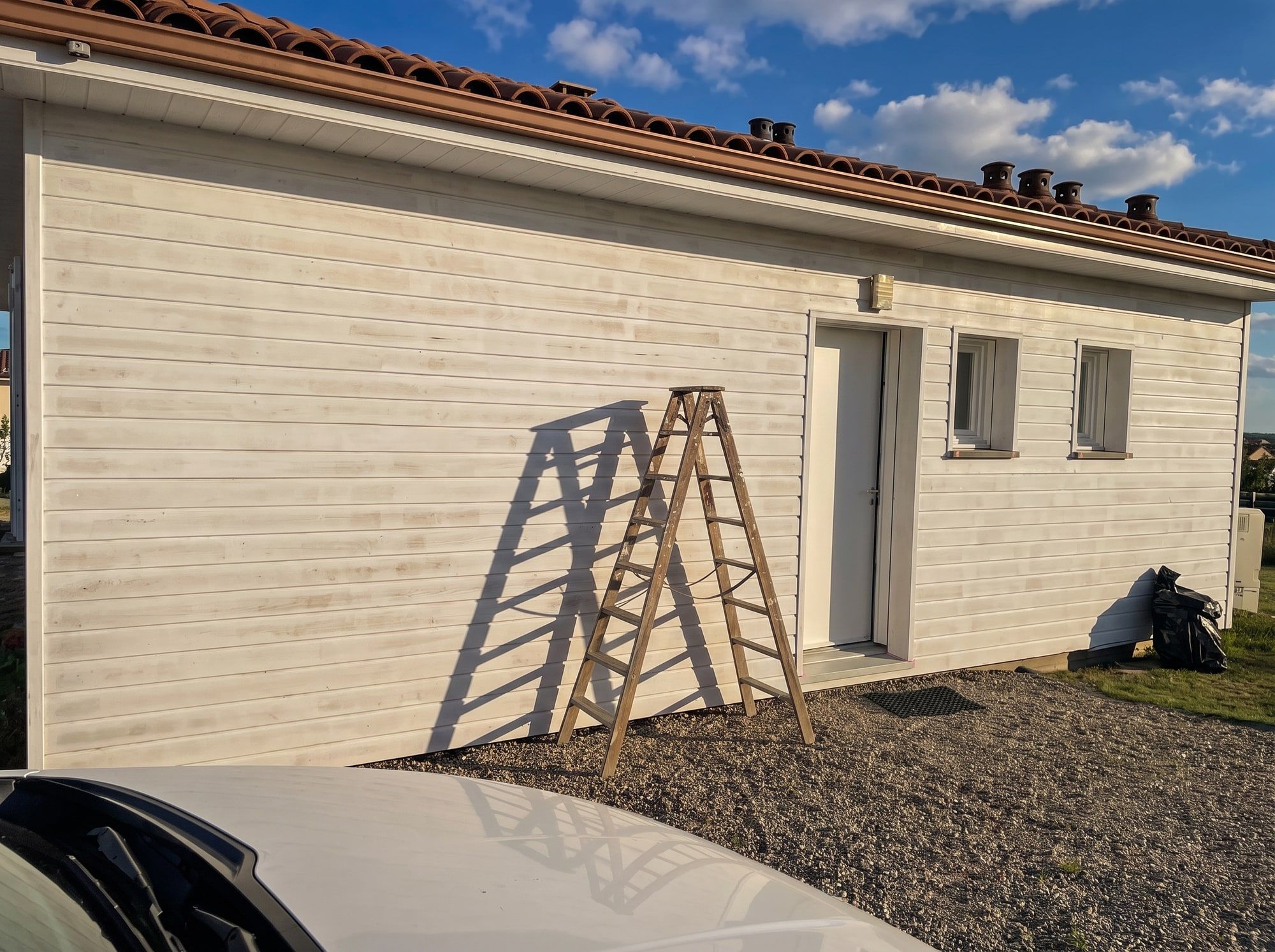 Première couche d’impression Unikalo Unistop Bois Evo Prim sur le bardage bois dégrisé, rénovation en cours à Castelnau-sur-Gupie
