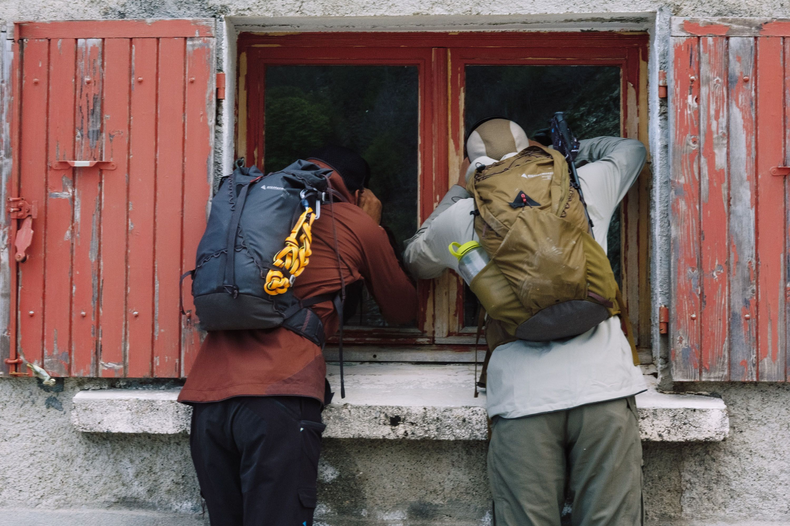 Two men looking in through a window