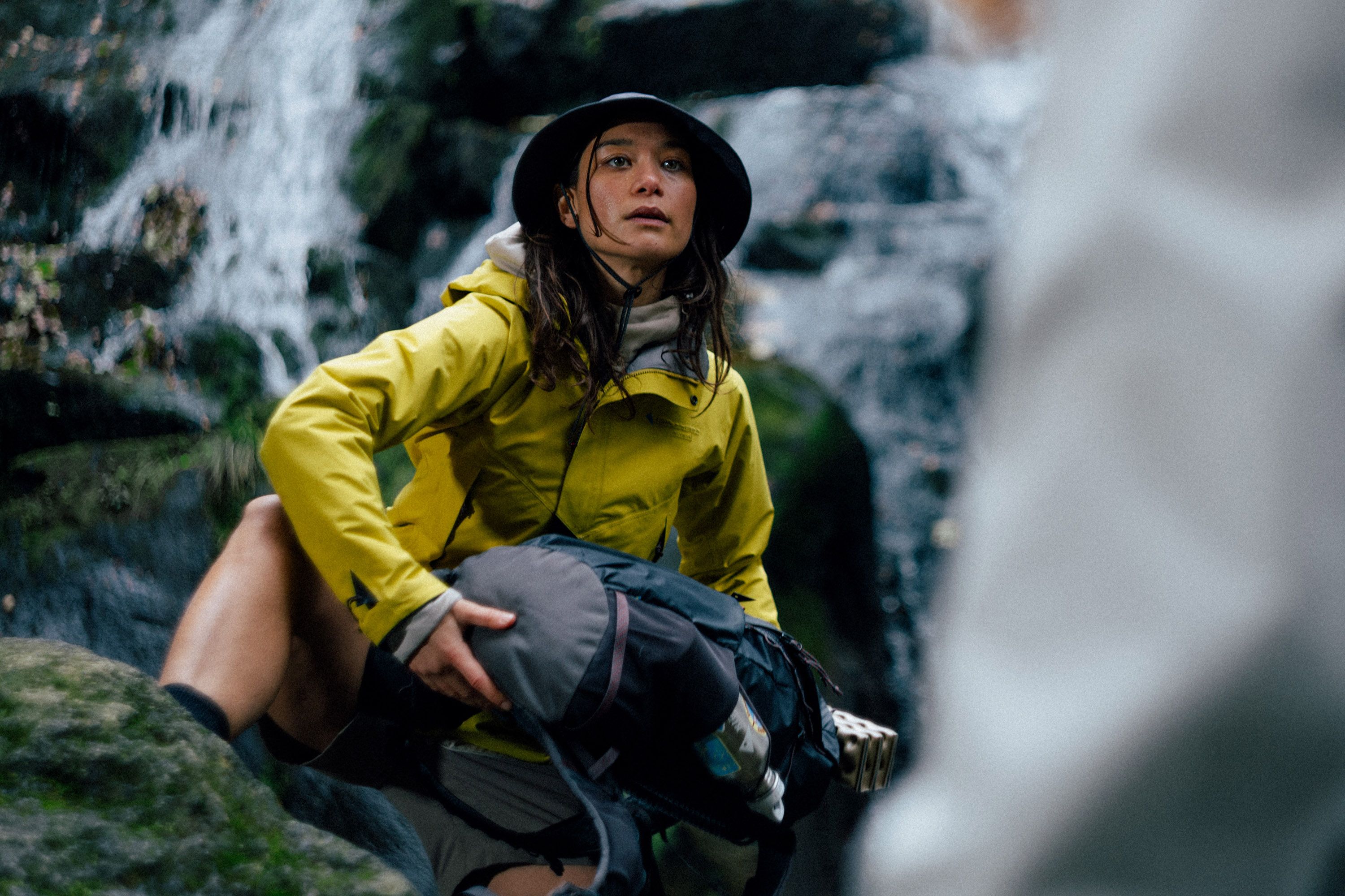 Woman sitter on a rock by a waterfall