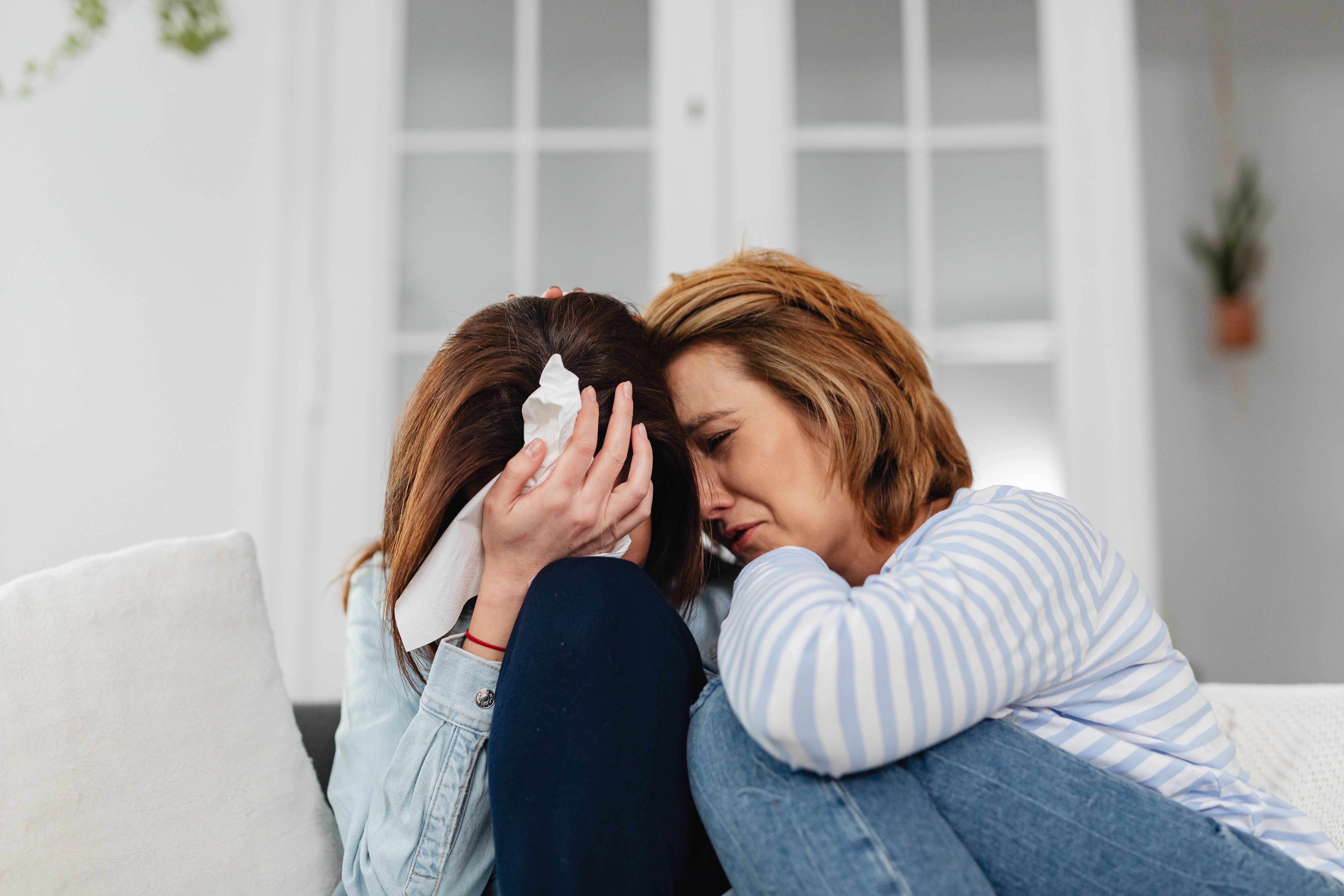 Mujer afligida consolada por su madre tras la muerte injusta de un familiar en Houston, Texas