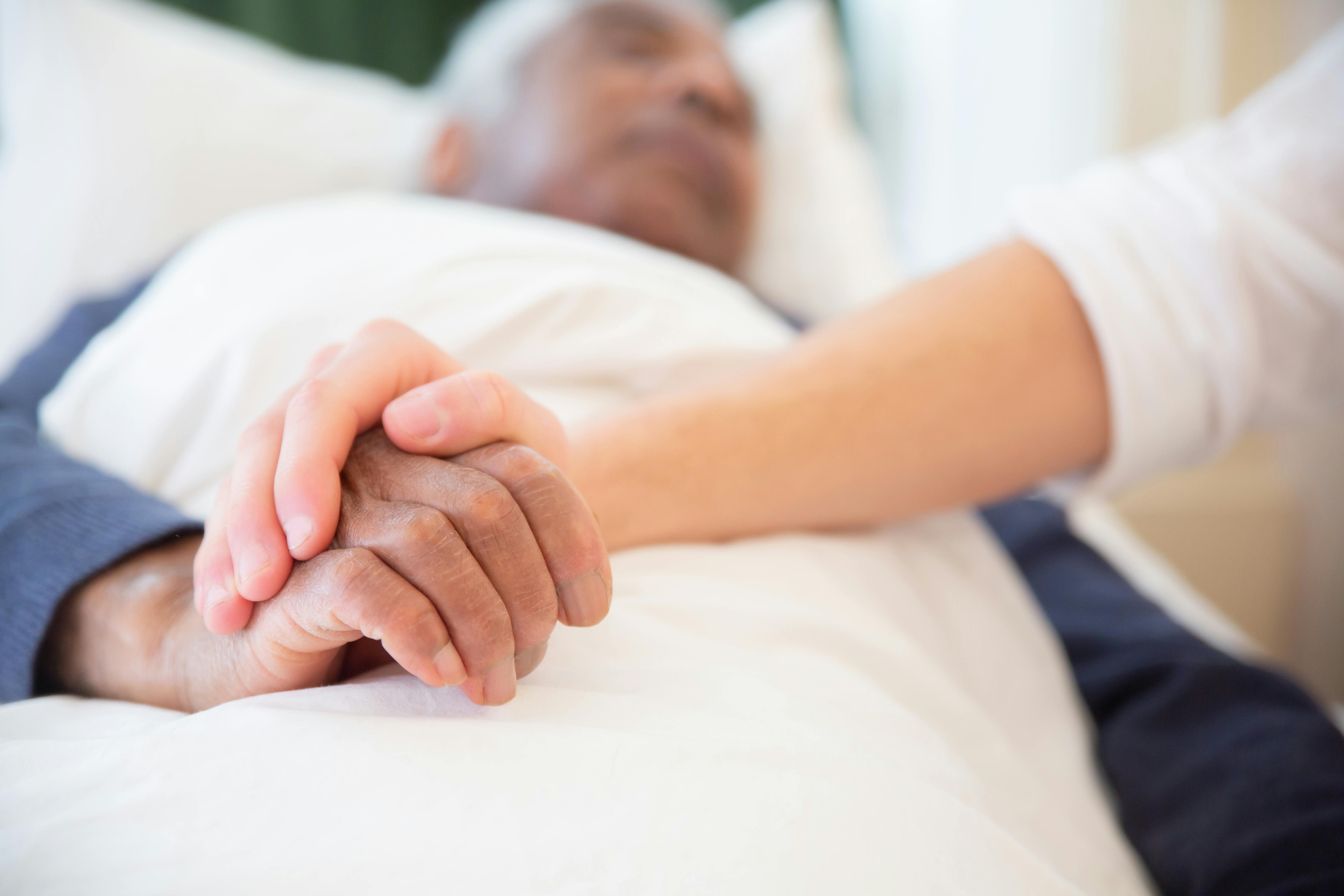 Image Paciente hospitalizado tomado de la mano, mostrando cómo las barreras del idioma en hospitales pueden afectar la seguridad del paciente.