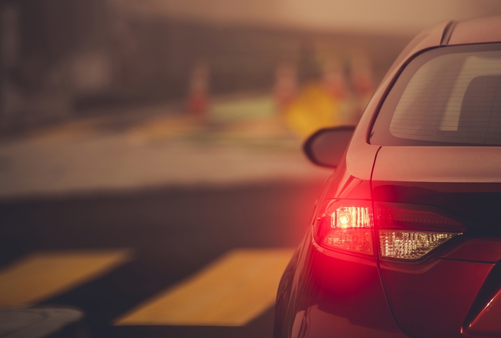Image Rear view of a car stopped at an intersection with brake lights illuminated after a left turn crash, illustrating a common traffic accident scenario in Texas.