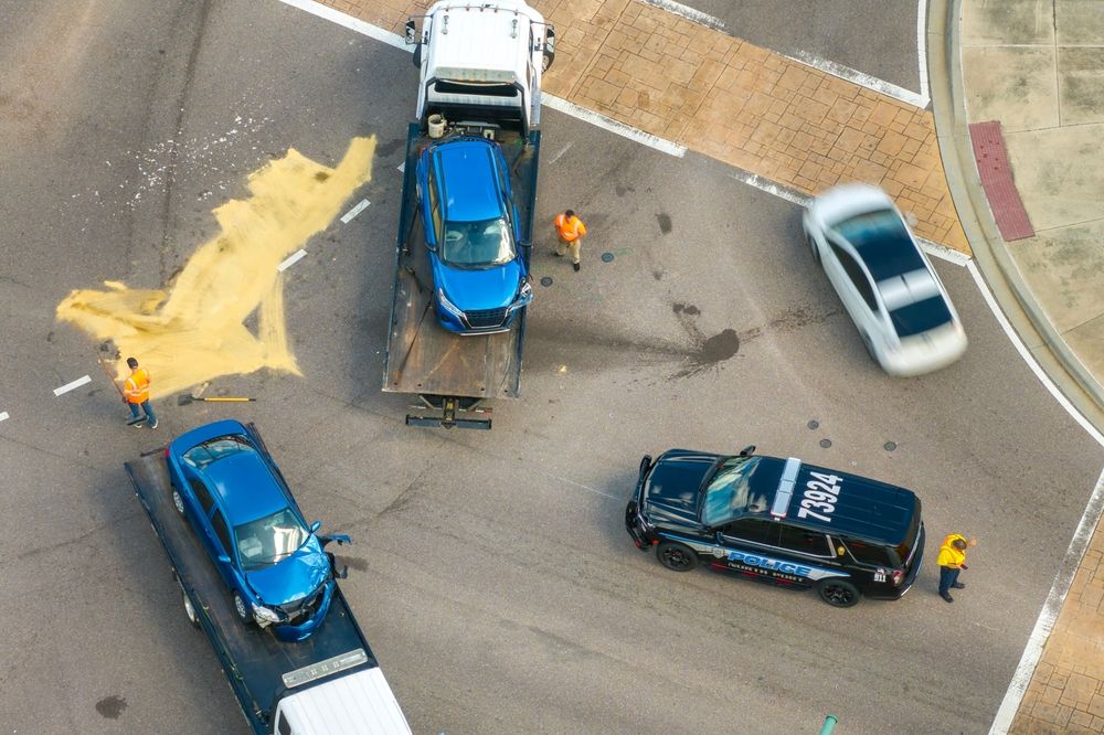 Aerial view of a major traffic accident scene with damaged vehicles, police presence, and workers cleaning debris after a serious car wreck in Texas