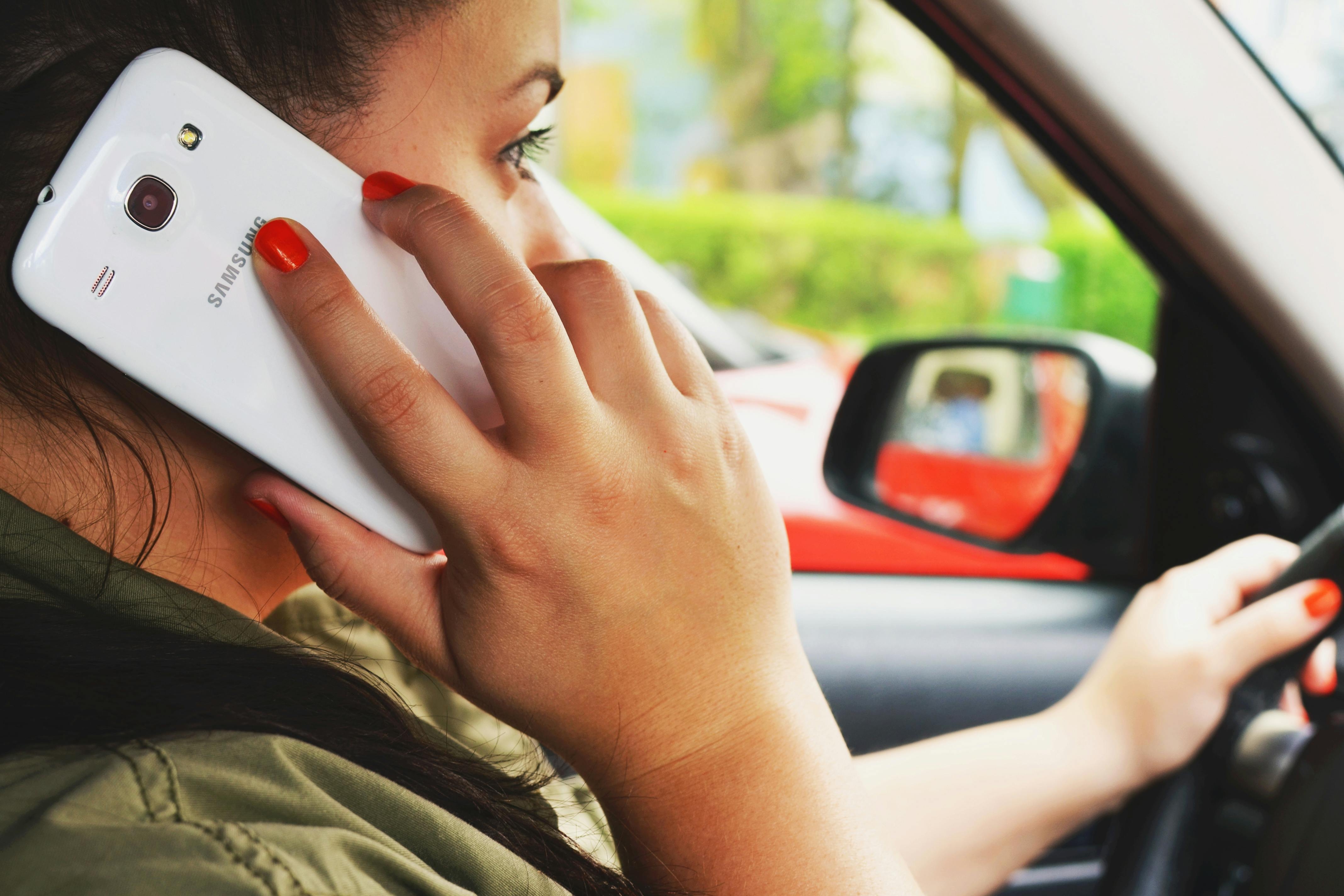 Image Conductora usando teléfono mientras maneja representando conducción distraída y riesgo de accidente en Houston