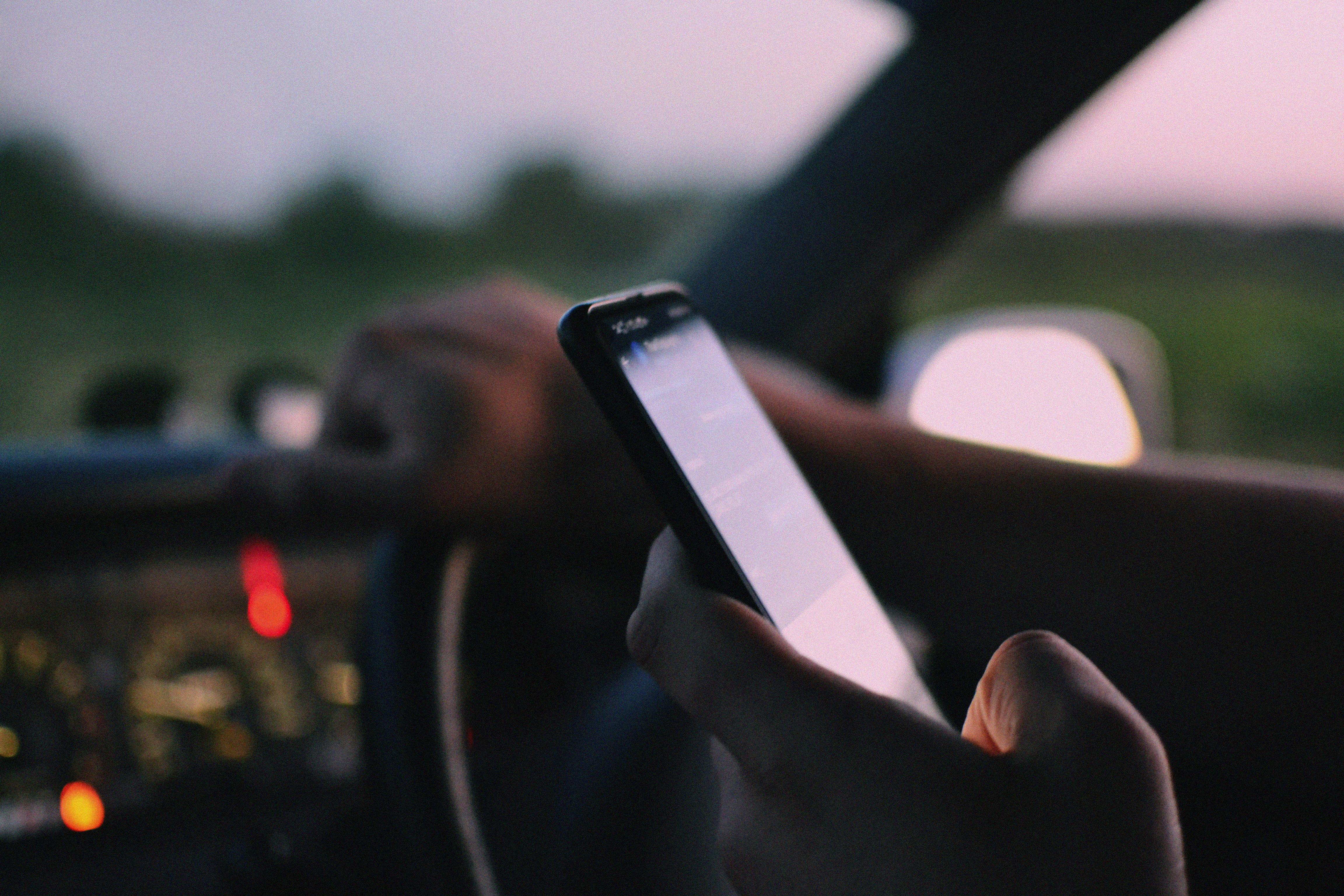 Driver using phone behind the wheel at night representing distracted driving accident risk and evidence needed to prove a case in Houston