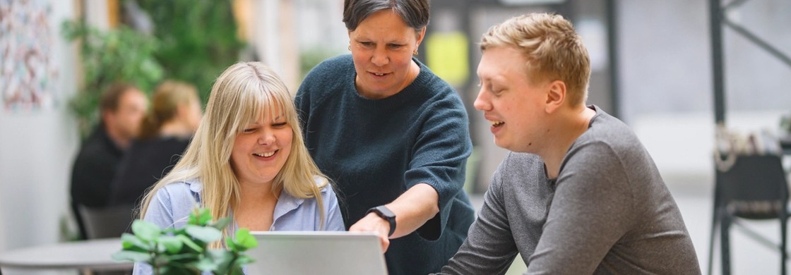 En grupp lärare pratar och tittar tillsammans på en dator