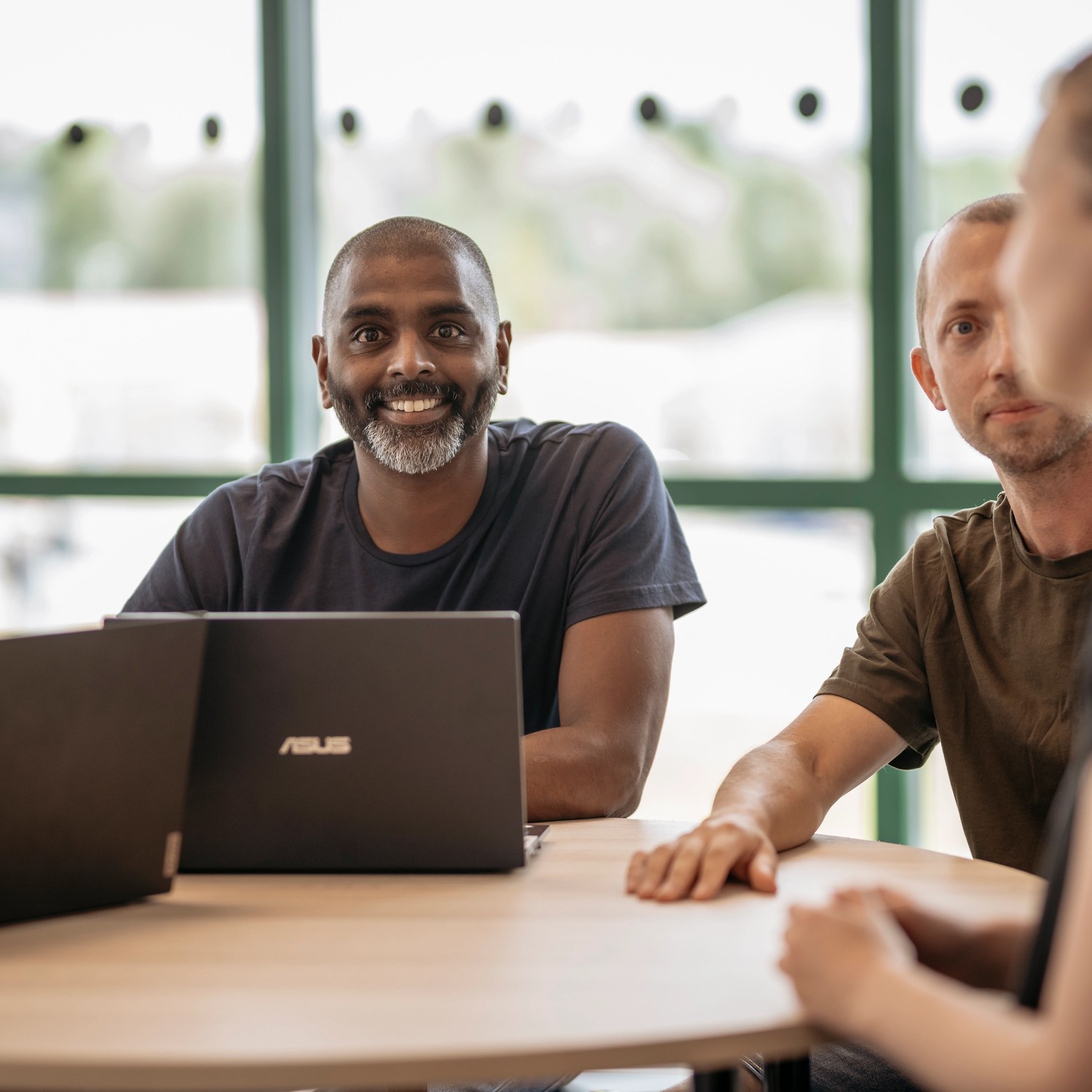 Lärare sitter tillsammans med datorer runt bord