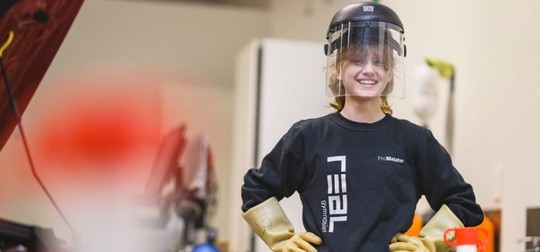 Elev med visir i bilverkstad