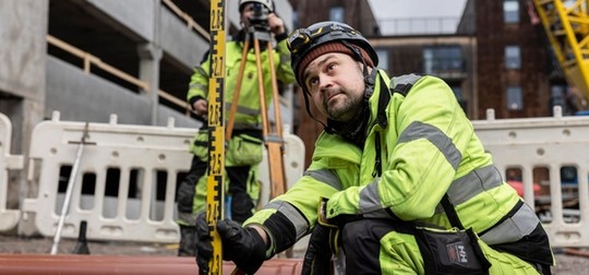 Två män som mäter på en byggarbetsplats