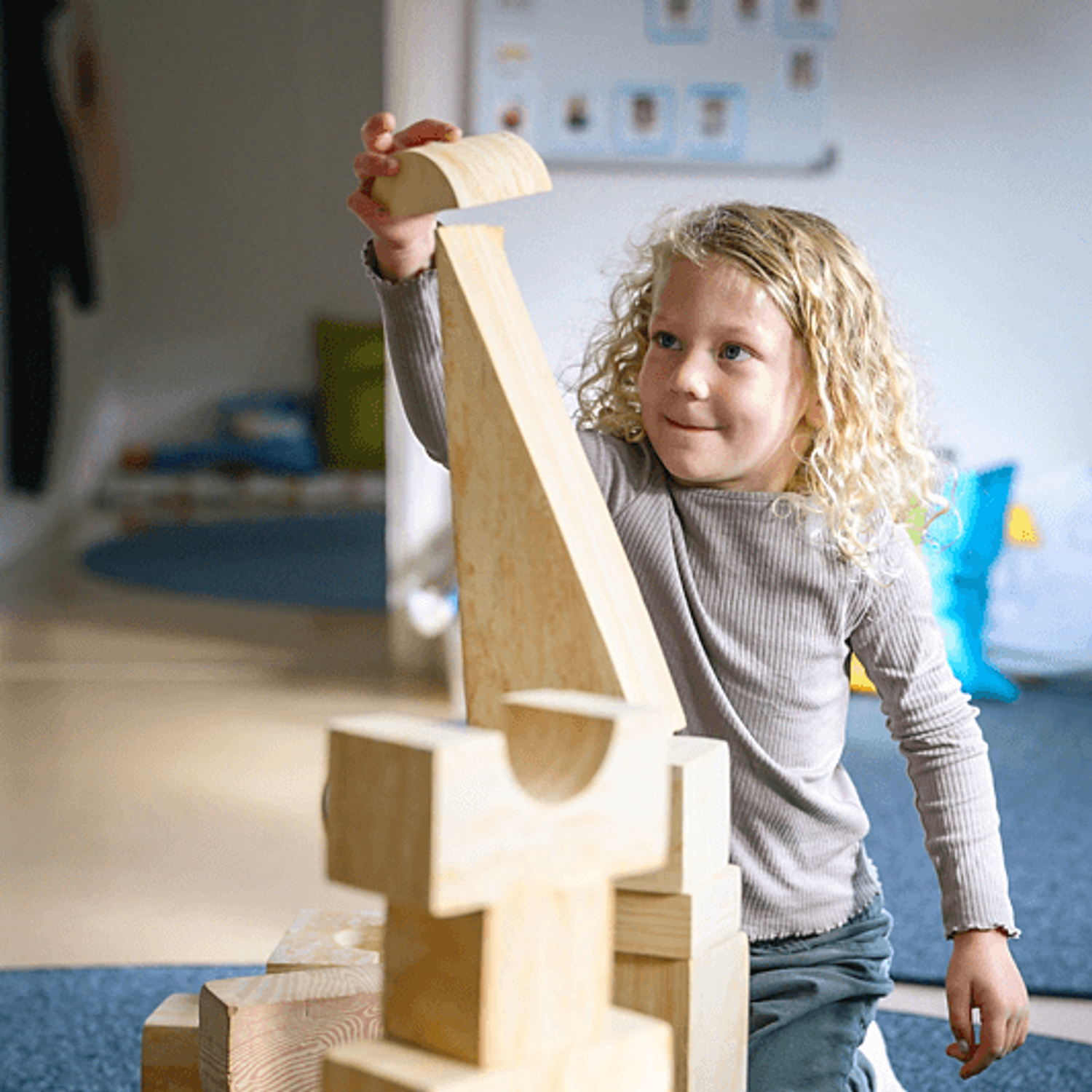 Flicka bygger torn av klossar