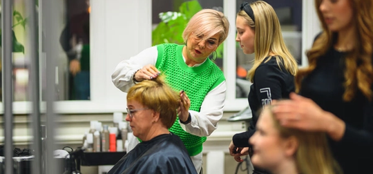 pedagog visar håruppsättning för elev