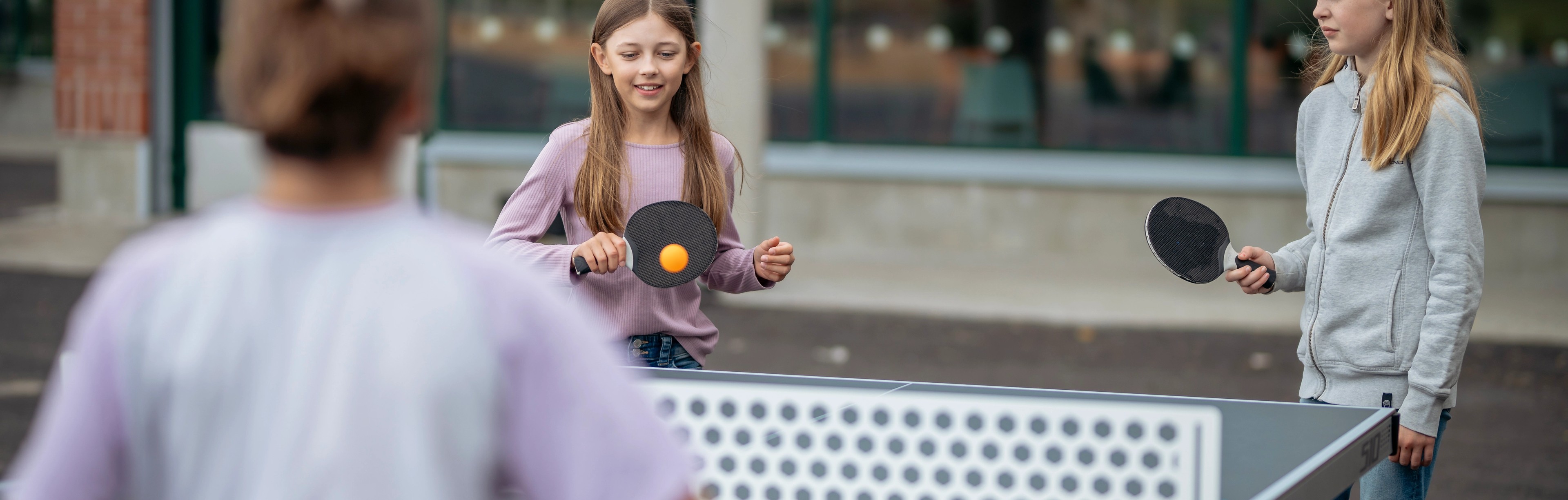 Barn spelar pingis på skolgård