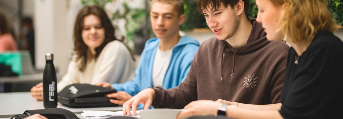 Elever arbetar tillsammans i uppehållsrum.