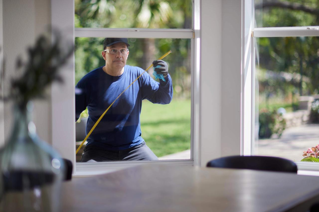 Window installation contractor measuring a window