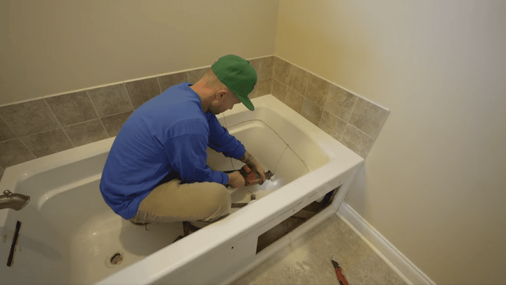 man deconstructing tub for removal