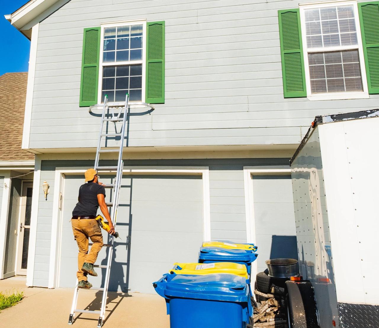 window installer climbing a ladder