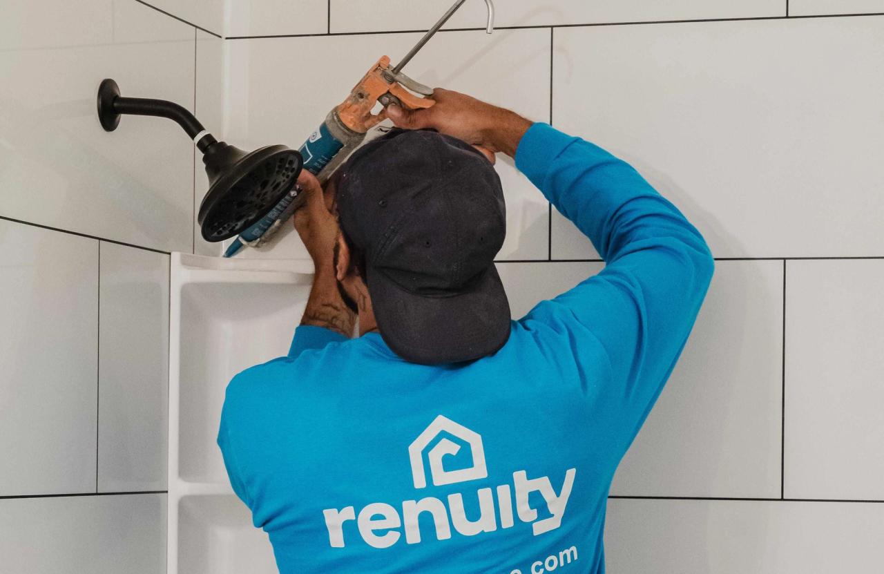 Renuity installer sealing a shelf in a walk-in shower
