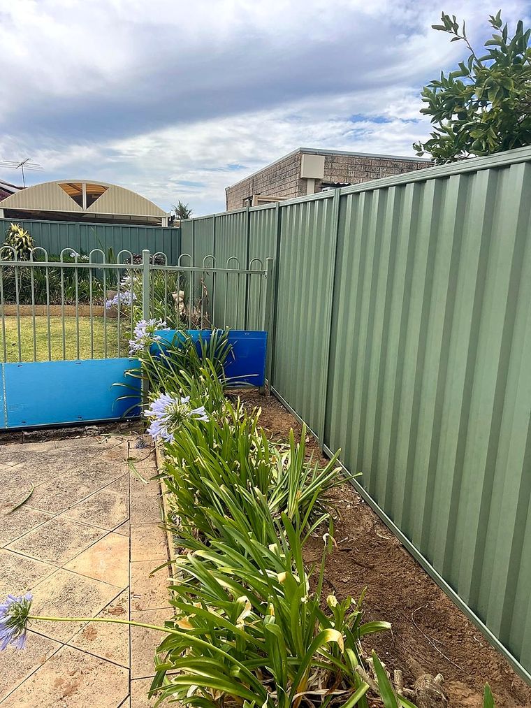Black tubular pool fencing alongside a Colorbond boundary in a Perth Hills garden