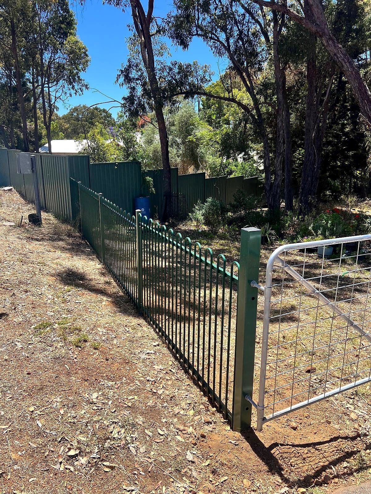Green tubular steel security fencing transitioning to a wire farm gate on a bushland Perth Hills property