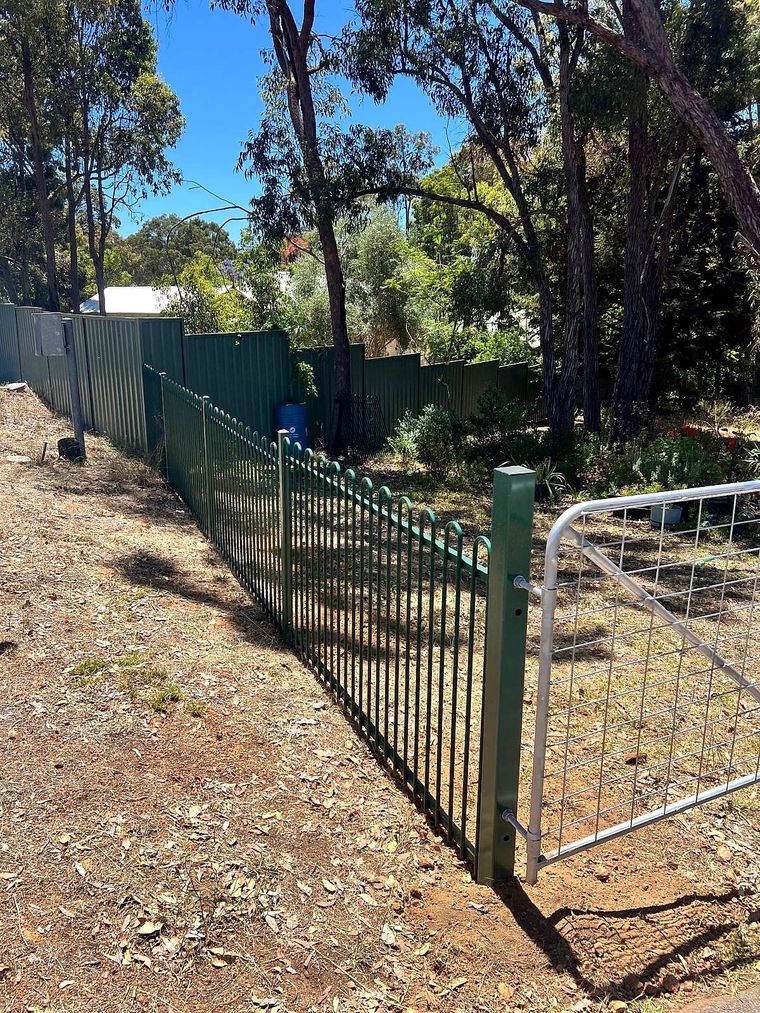 Green tubular steel security fencing transitioning to a wire farm gate on a bushland Perth Hills property