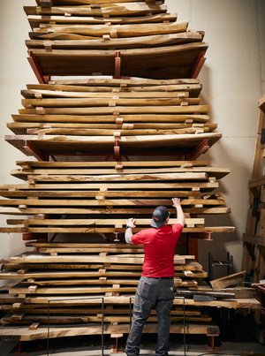 Man navigating large pile of wood