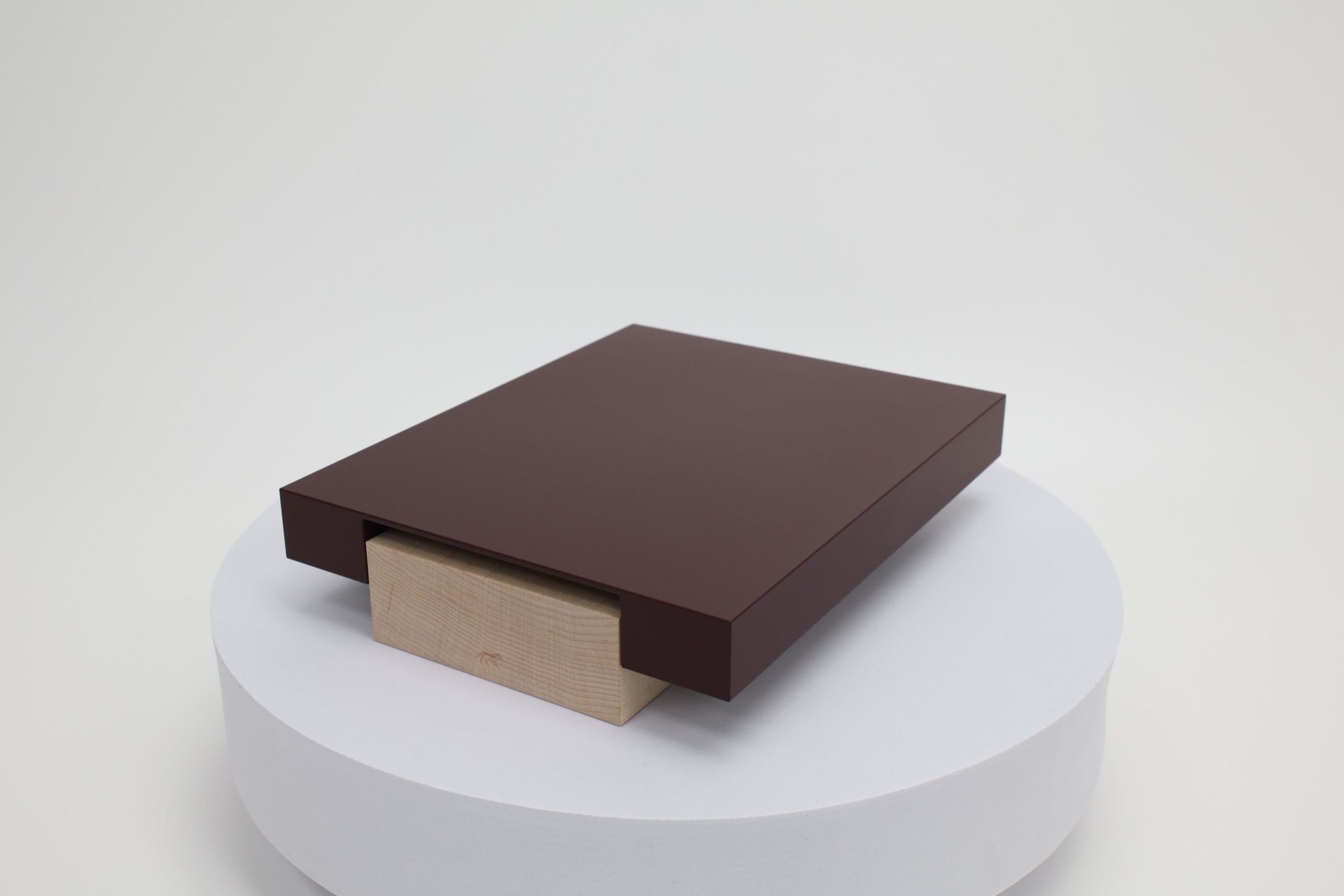 The Vora Aegis prototype: a maroon aluminum body over a maple base, photographed in the studio.