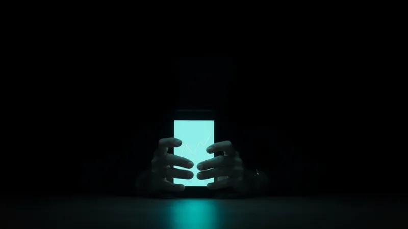 Two hands cradling a glowing phone in total darkness, a rising chart on the screen. The screen was the memory of possession. Not your keys, not your coins; not your keys, not your memory.