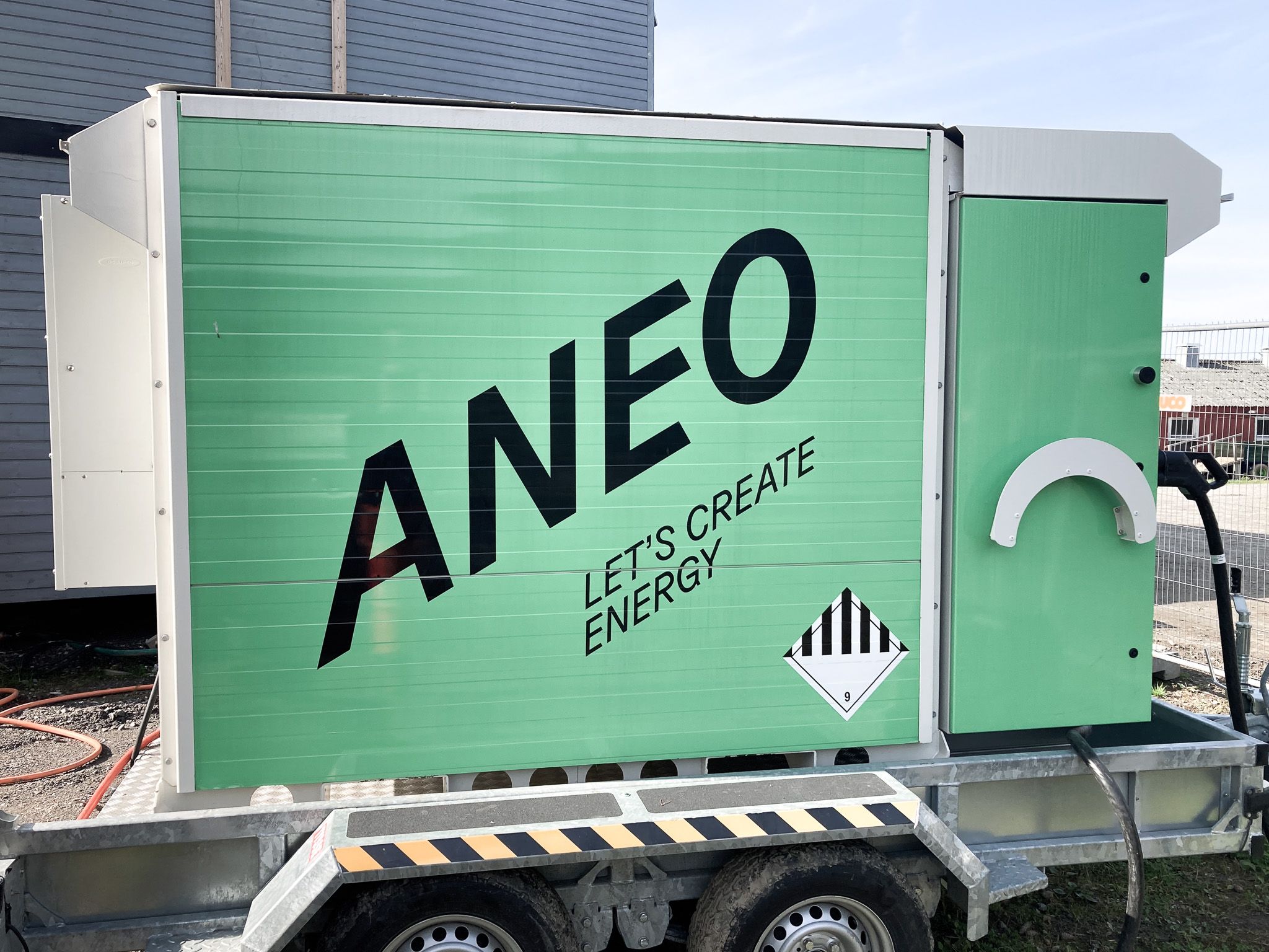 En grønn tilhenger med svart tekst på som sier "Aneo".