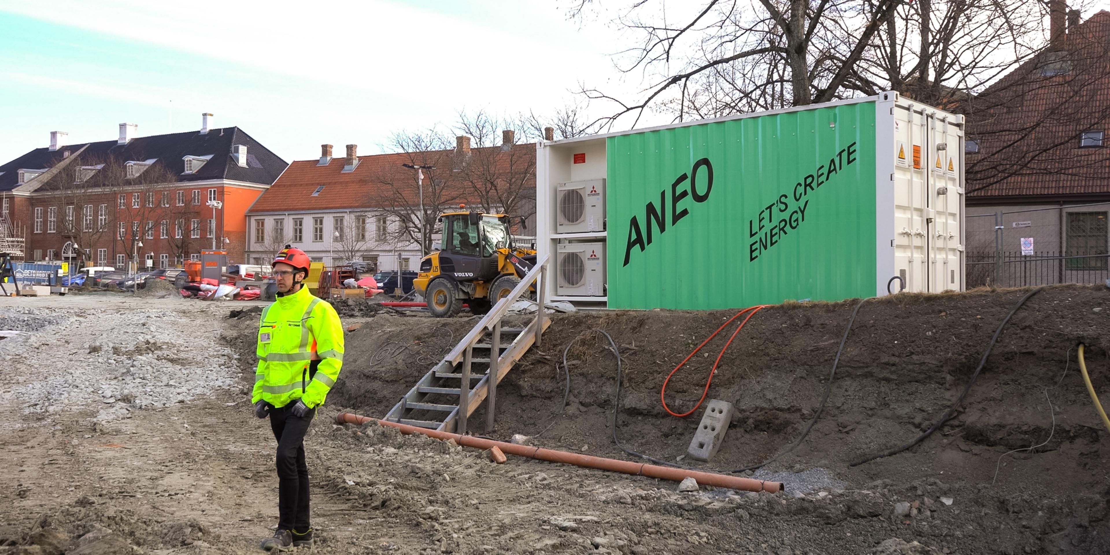 Mann på byggeplass med ladecontainer i bakgrunn