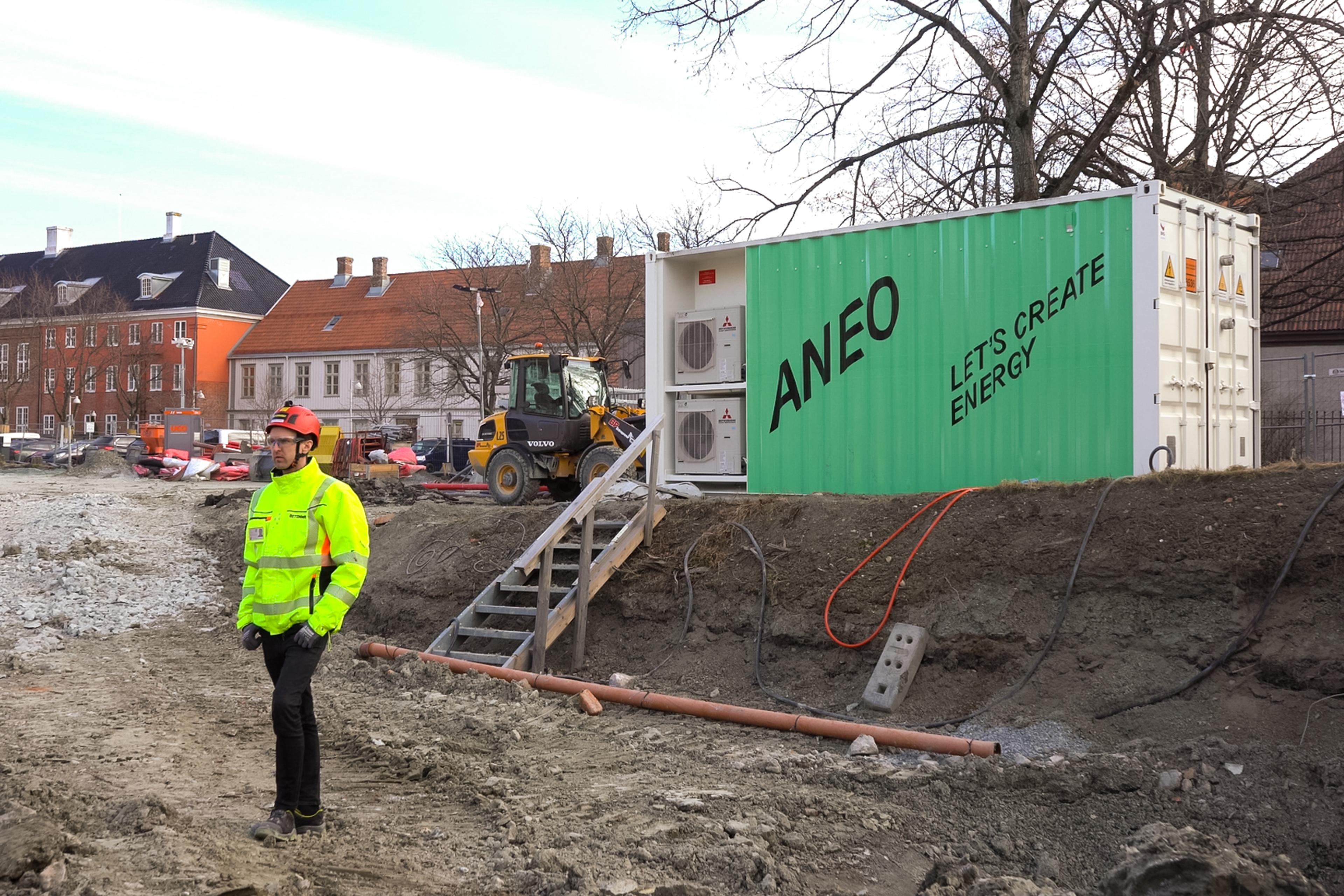 Mann på byggeplass med ladecontainer i bakgrunn