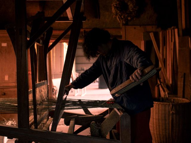 Sunami-san weaving igusa rush grass on a traditional loom in his workshop.
