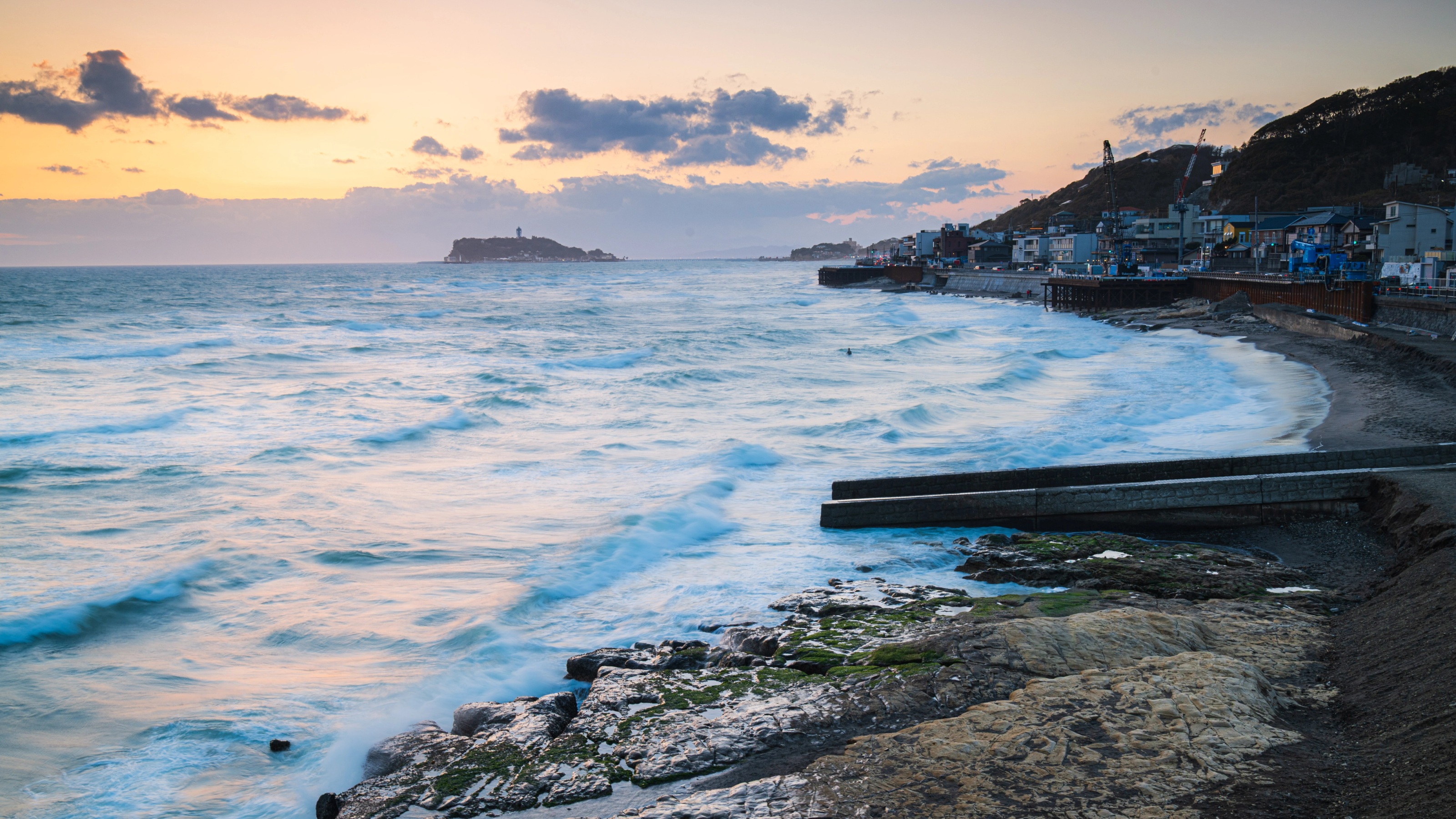La côte de Shōnan et l’île d’Enoshima au crépuscule, sous une mer agitée.