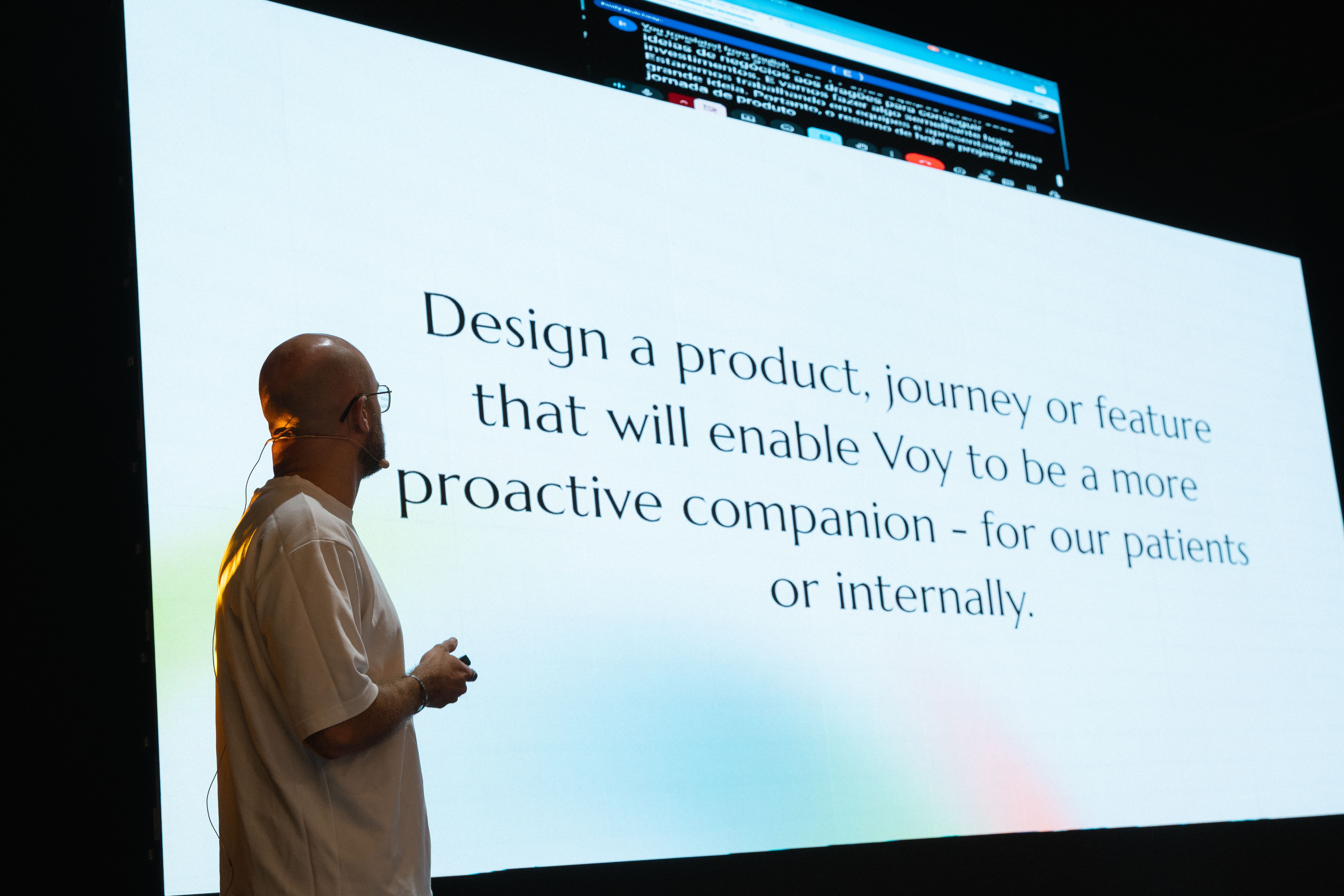 Voy VP of Brand looking towards a slide on a large screen