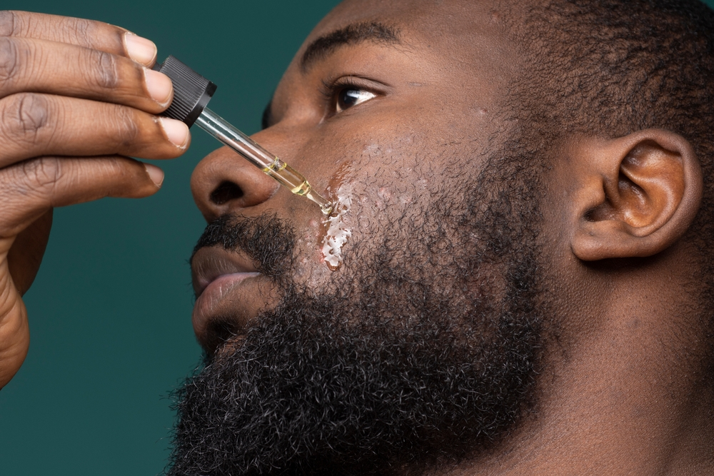 man with beard using oil