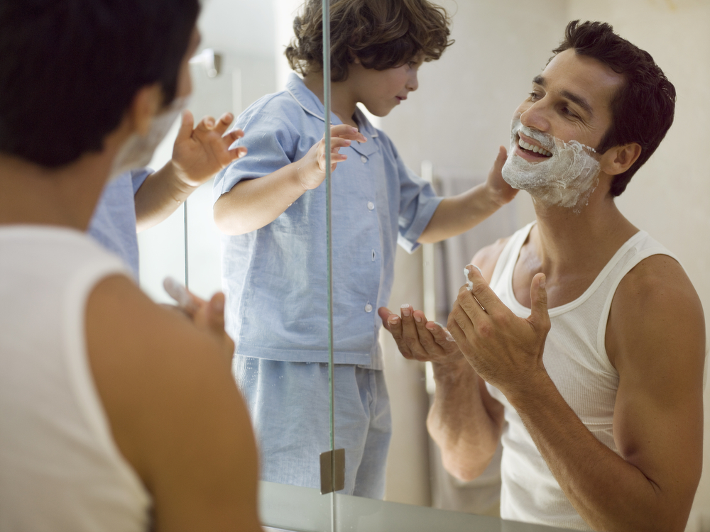 father and son shaving int he mirror