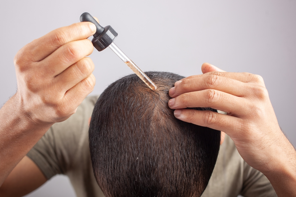 man adding product to hair