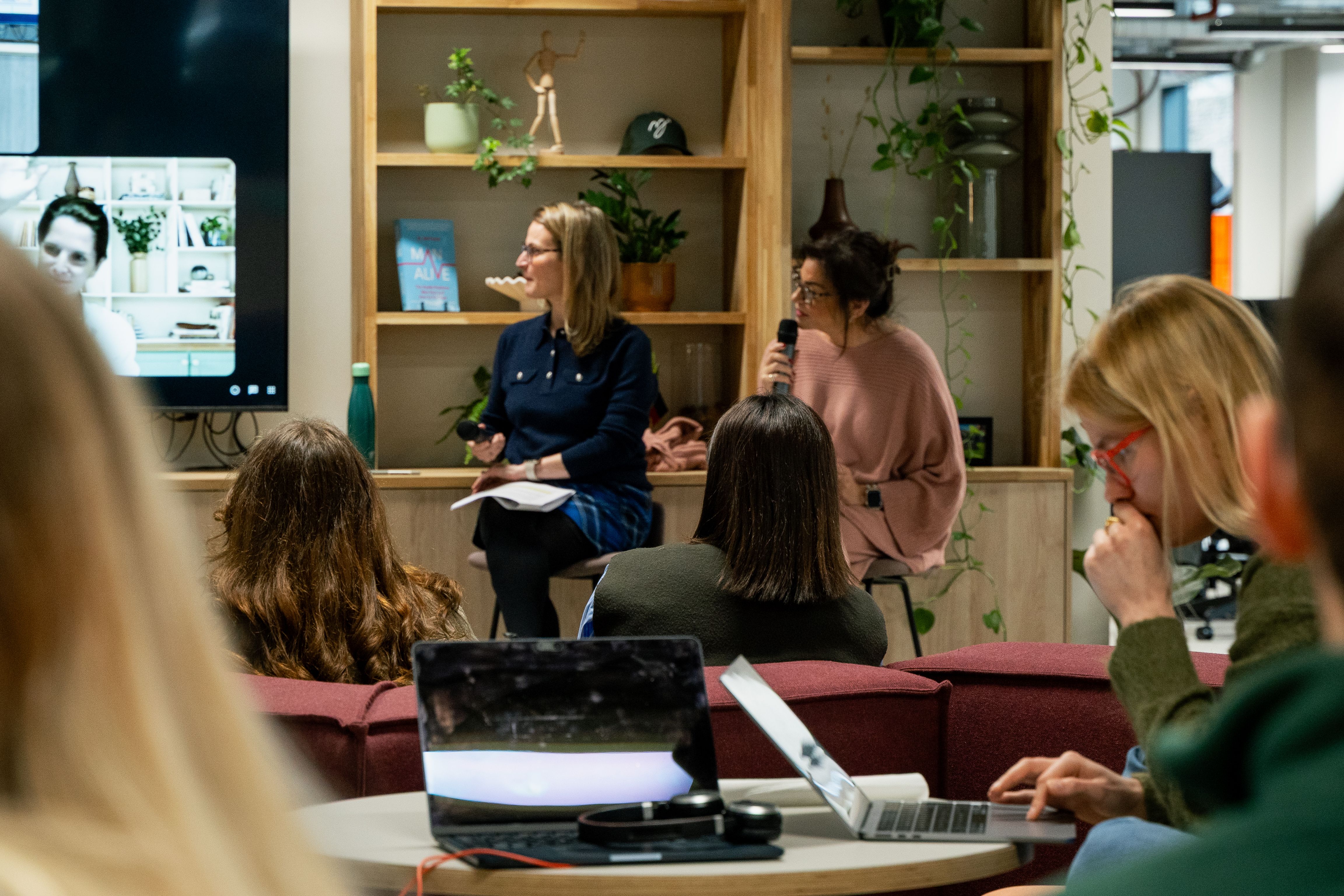Two panellists speaking in front of an audience