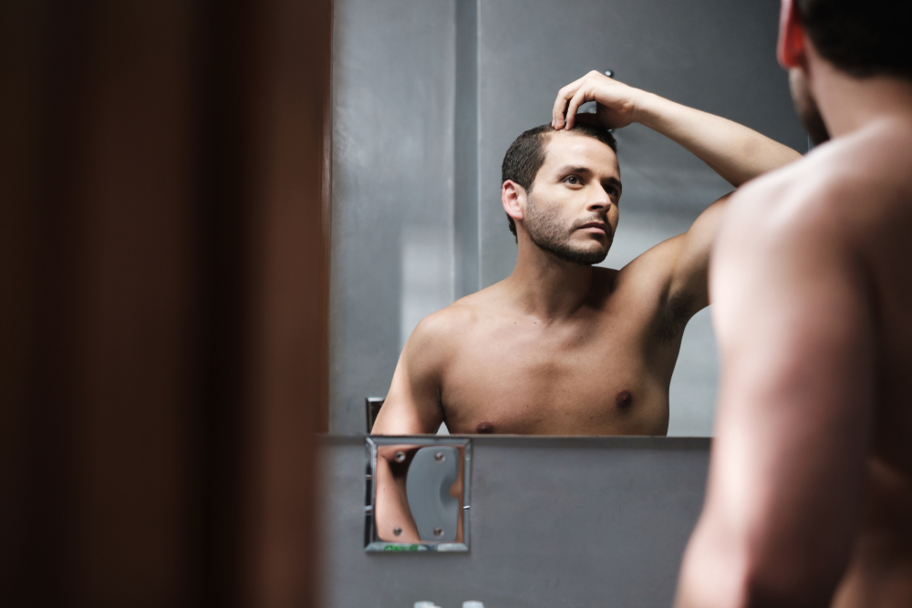 man in the mirror checking hair